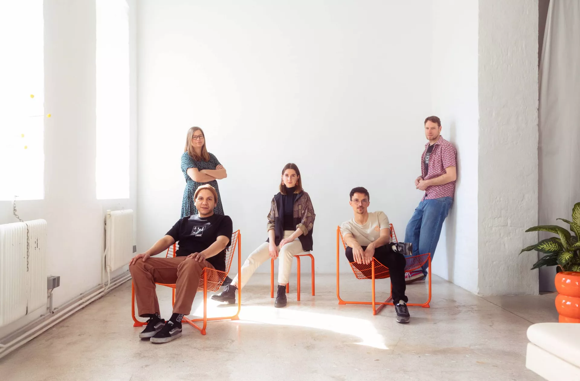 lowfidelity team. fünf personen in einem hellen raum. alle schauen ernst in die kamera.