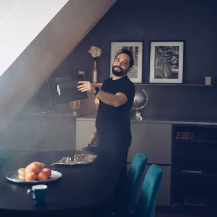 Mann fächert auf einem Filmset mit einer Mappe Nebel aus der Nebelschmaschine.